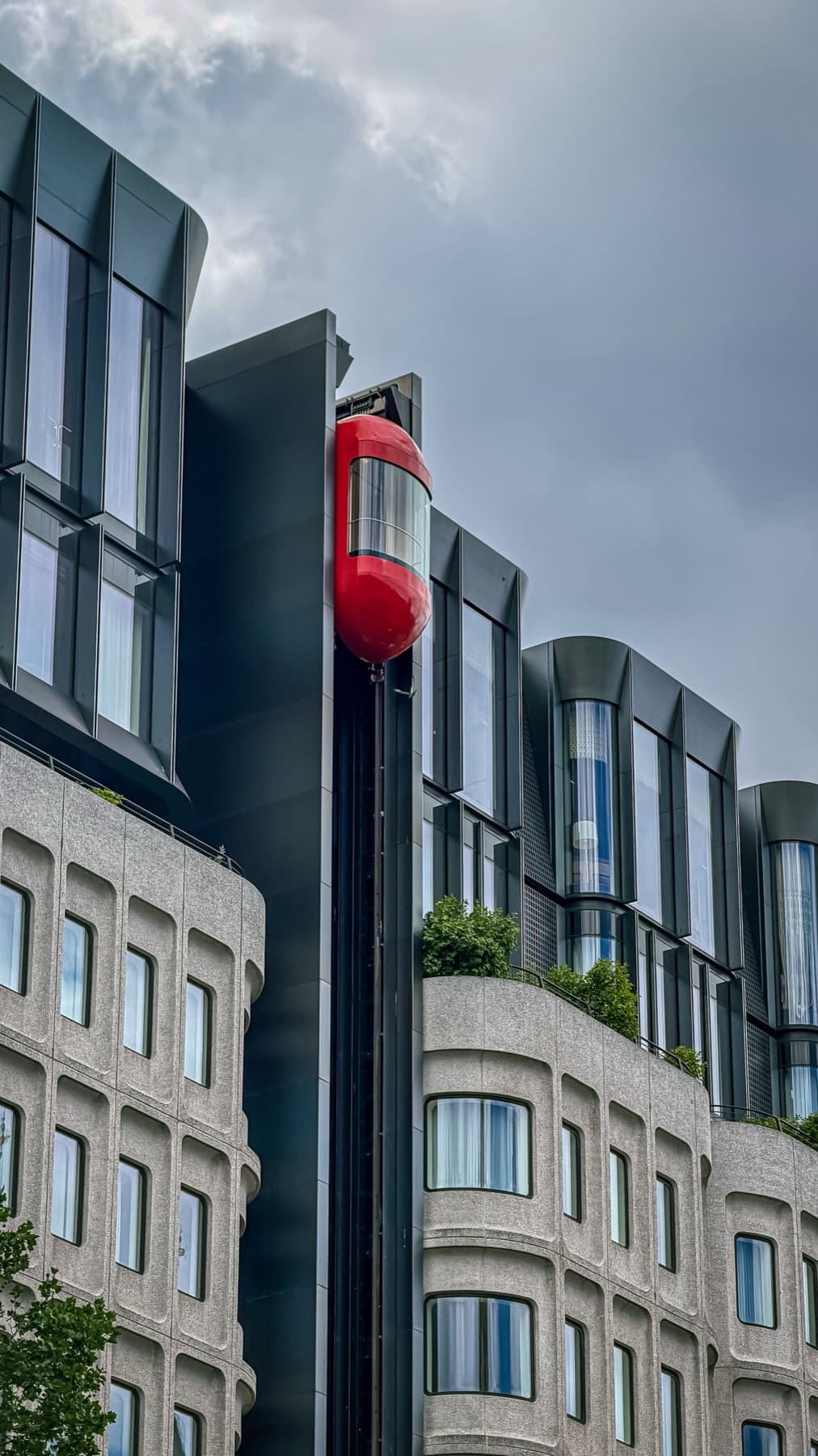 Red capsule lift on the facade of a modern building